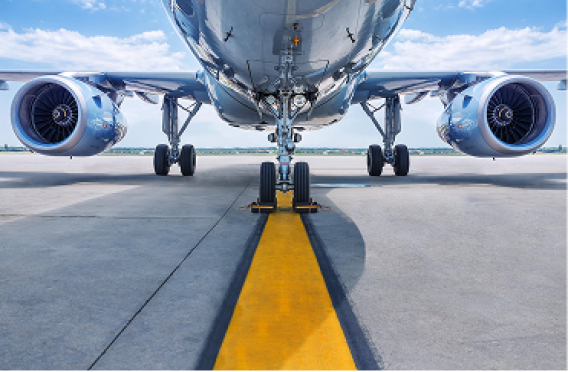 Front view of a commercial jet airplane on a runway, showing nose gear and engines.