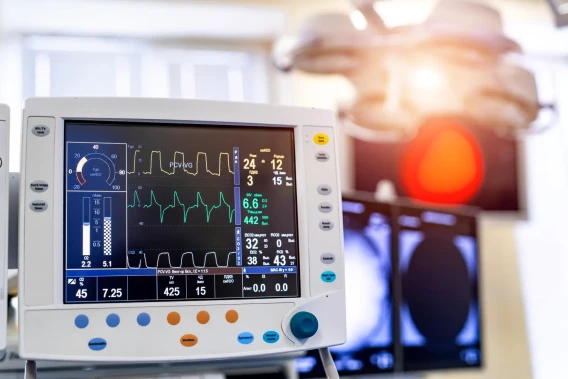 Close-up of a hospital ventilator monitor displaying respiratory waveforms and patient readings.