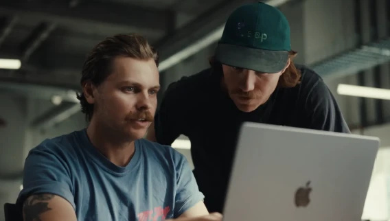 Two startup team members reviewing information together on a laptop in a modern workspace.