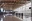 Spacious airport terminal interior with self-service kiosks and large glass windows.