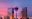 Calgary skyline at sunset featuring the Calgary Tower and illuminated downtown buildings.